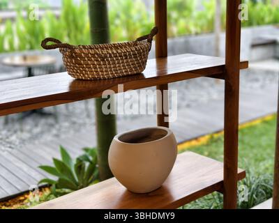 Ripiano decorativo con cestello in vimini e pentola in ceramica per esterni Foto Stock