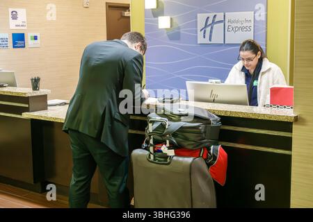 Orlando Florida, Holiday Inn Express & Suites Orlando East UCF area IHG, hotel, interno, banco prenotazioni per il check-in nella lobby, uomo d'affari Foto Stock
