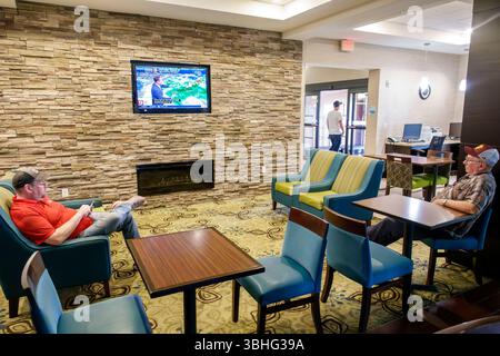 Orlando Florida, Holiday Inn Express & Suites Orlando East UCF area IHG, hotel, interno, area salotto lobby lounge, uomini adulti seduti Foto Stock