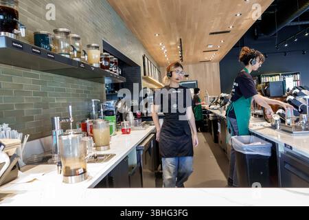 Orlando Florida, caffè Starbucks, interno, baristi dietro il bancone, lavoro di squadra del dipendente, preparazione di bevande al caffè, distributori di tè freddo, caffè espresso mac Foto Stock