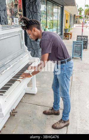 Melbourne, Florida, Eau Gallie Arts District, Highland Avenue, piano pubblico sul marciapiede, musicista adulto di sesso nero che suona strumenti di strada, superba Foto Stock