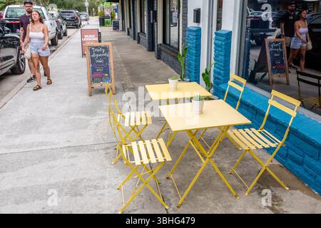Melbourne, Florida, Eau Gallie Arts District, Highland Avenue, caffè sul marciapiede, tavoli gialli e sedie, posti a sedere all'aperto, piccolo ristorante, lavagna a menu Foto Stock