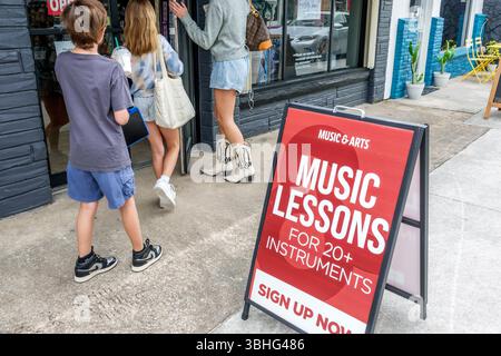 Melbourne, Florida, Eau Gallie Arts District, Highland Avenue, negozio di musica e arti, mostra di insegne della scuola di musica sul marciapiede, boa di pubblicità rossa con cornice A Foto Stock