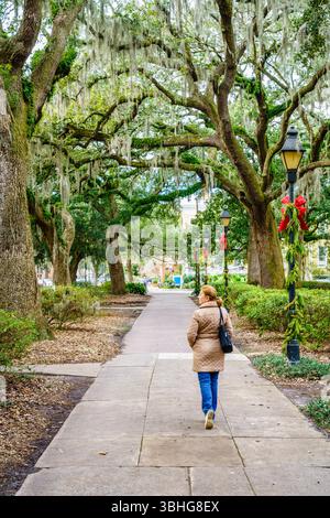 Una donna sta camminando lungo un vicolo panoramico di Forsyth Park a Savannah, Georgia Foto Stock