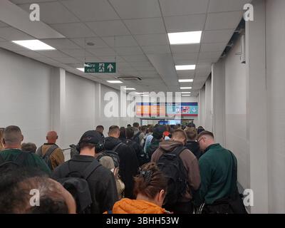 coda di una lunga coda serpeggiante per l'immigrazione nella sala degli arrivi dell'aeroporto di luton londra inghilterra regno unito Foto Stock