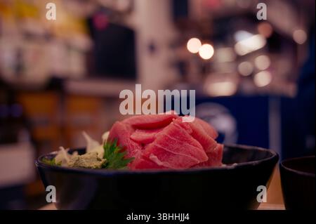 Ciotola di riso con sashimi di tonno servita con wasabi e foglie di shiso in un ristorante tradizionale di Tokyo Foto Stock