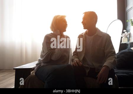Coppia senior che condivide momenti intimi in camera da letto durante l'alba Foto Stock