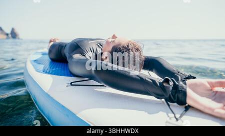 Surf Paddleboard Water rilassante a bordo dopo una sessione di surf. Foto Stock