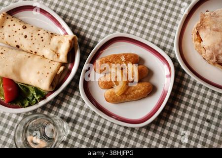 Colazione tradizionale balcanica con pancake, dessert kalac e panino con carne, formaggio e verdure. Vista dall'alto. Foto Stock