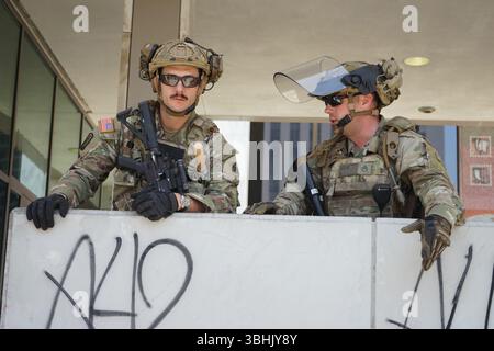 (250610) -- LOS ANGELES, 10 giugno 2025 (Xinhua) -- i soldati della Guardia Nazionale della California sono a guardia di un edificio di un'istituzione federale nel centro di Los Angeles, California, Stati Uniti, il 9 giugno 2025. Migliaia di truppe e polizia statunitensi stavano ancora circondando piccoli gruppi di manifestanti pacifici nel centro di Los Angeles entro lunedì a mezzogiorno, dopo ore di confronto. La dimostrazione senza precedenti di forza militare sulle strade americane si trova in mezzo a una crisi costituzionale tra l'amministrazione Trump e lo stato della California per quanto riguarda l'applicazione dell'immigrazione. (Foto di Zeng Hui/Xinhua) Foto Stock