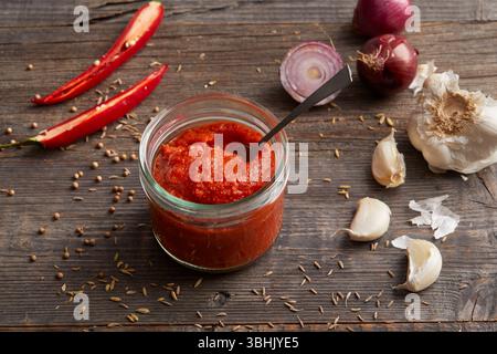 Pasta di Harissa, una pasta piccante di peperoncino nordafricano fatta con peperoni rossi, aglio e spezie Foto Stock