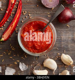 Pasta di Harissa, una pasta piccante di peperoncino nordafricano fatta con peperoni rossi, aglio e spezie Foto Stock