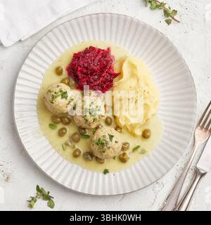 Polpette tedesche in salsa cremosa di capperi. Polpette tradizionali tedesche note come Königsberger Klopse, servite in una cremosa salsa bianca con capperi. Foto Stock