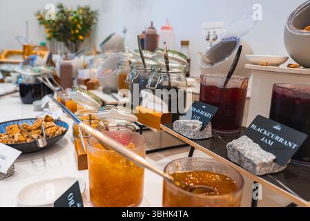 Colazione a buffet con marmellate, miele e granola sul piano bianco Foto Stock