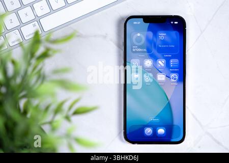 Poznan, Polonia - 10 giugno 2025: Moderno schermo per smartphone che presenta il nuovo sistema operativo iOS 26 con la sua interfaccia Liquid Glass, che offre un versat Foto Stock
