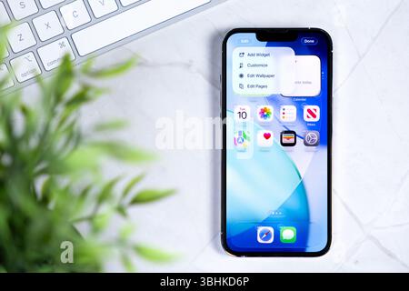Poznan, Polonia - 10 giugno 2025: Un moderno smartphone Apple iPhone che presenta l'innovativo sistema operativo iOS 26 con il suo design Liquid Glass Foto Stock