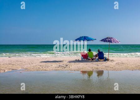 Due persone con sdraio e ombrelloni a Siesta Beach a Siesta Key, Sarasota, Florida Foto Stock