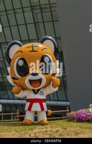 Muju, Corea del Sud. 1 maggio 2019: Statua di Taekwondowon, mascotte Tae Rang che indossa l'uniforme con cintura rossa in piedi davanti all'arena da competizione Foto Stock