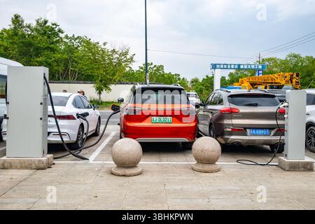 Le auto elettriche vengono caricate presso una stazione di ricarica. Provincia di Jiangsu, Cina. Foto Stock