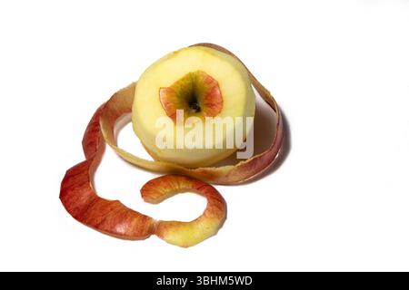 Immagine di una mela sbucciata con una buccia accanto ad essa. Foto Stock