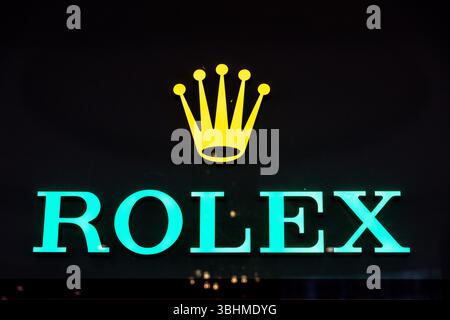 Casablanca, Casablanca-Settat - Marocco - 07-27-2024: Logo Rolex illuminato in turchese con sopra corona dorata. Foto Stock