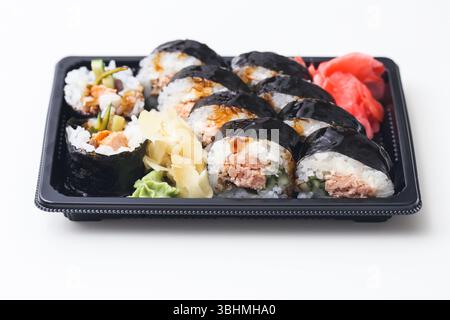 Sushi da asporto nel vassoio nero Primo piano del cibo giapponese. Panini assortiti con tonno, riso, wasabi e zenzero. Pranzo al sacco fresco. Delizioso pasto tradizionale. Foto Stock