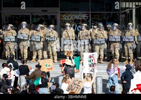 LOS ANGELES, CALIFORNIA - 9 GIUGNO: La Guardia Nazionale sta di guardia ad un edificio mentre le proteste continuano dopo tre giorni di scontri con la polizia dopo che 'continuano i raid di immigrazione e 'l'amministrazione Trump ha chiamato la Guardia Nazionale il 9 giugno 2025, a Los Angeles, California. “L’amministrazione Trump ha ordinato ai funzionari di aumentare le detenzioni a 3.000 migranti al giorno. (Foto di Michael Nigro/Sipa USA) credito: SIPA USA/Alamy Live News Foto Stock