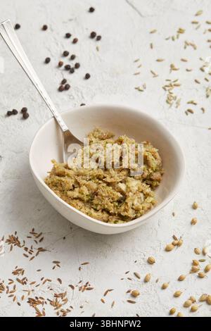Pasta di curry verde tailandese. A base di erbe fresche, peperoncini, aglio e citronella, serviti in una ciotola rustica. Perfetto per una cottura veloce e piatti caldi. Foto Stock