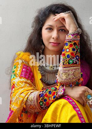 Bella donna vestita con vibranti abiti gujarati tradizionali con gioielli ossidati, perfetta per le celebrazioni Navratri e Garba. Foto Stock