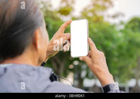 Primo piano foto di un vecchio uomo dai capelli grigi che parla sulla fotocamera del telefono sullo sfondo naturale. Messa a fuoco selettiva, isolamento dello schermo. Foto Stock