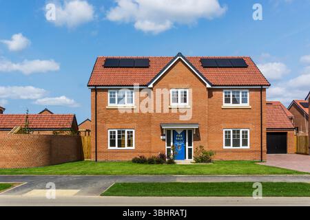 Nuova casa indipendente con quattro camere da letto su due fronti in vendita a South Wootton, alla periferia di King's Lynn, Norfolk. Celle fotovoltaiche o pannelli solari sul tetto. Foto Stock