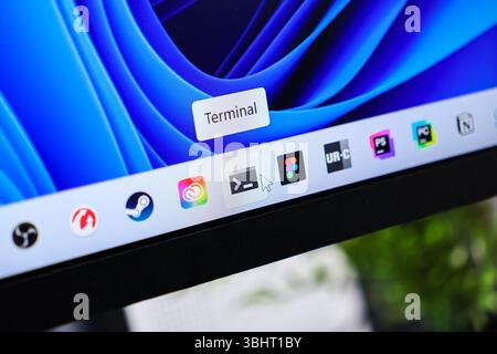 Poznan, Polonia - 6 giugno 2025: Sullo schermo viene visualizzata l'icona del terminale evidenziata dal cursore del mouse sulla barra delle applicazioni, che rappresenta l'amministrazione e la programmazione IT Foto Stock