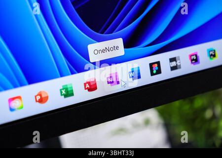 Poznan, Polonia - 6 giugno 2025: Vivace schermo del computer che mostra la barra delle applicazioni di Windows 11 con l'icona OneNote selezionata con un cursore del mouse Foto Stock