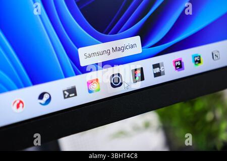 Poznan, Polonia - 6 giugno 2025: Primo piano della barra delle applicazioni di un moderno monitor con diverse scelte rapide per le applicazioni e un cursore del mouse, che mostra un attiv Foto Stock