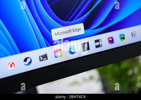 Poznan, Polonia - 6 giugno 2025: Icona dell'applicazione browser Microsoft Edge evidenziata da un cursore del mouse su una barra delle applicazioni del desktop Windows 11, che simboleggia l'inte Foto Stock