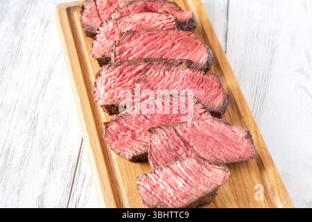 Tenera bistecca di mignon in filetto, perfettamente cotta, tagliata a fette e presentata elegantemente Foto Stock