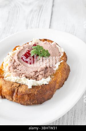 Sandwich di grano tostato con patè, formaggio cremoso e marmellata di mirtilli rossi Foto Stock