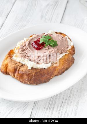 Sandwich di grano tostato con patè, formaggio cremoso e marmellata di mirtilli rossi Foto Stock