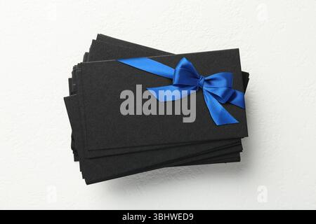 Carta regalo vuota con fiocco blu su sfondo bianco. Mockup per il design Foto Stock