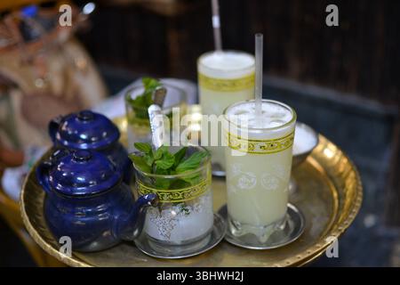 Tradizionale tè alla menta marocchino servito in bicchieri decorati su un vassoio dorato Foto Stock