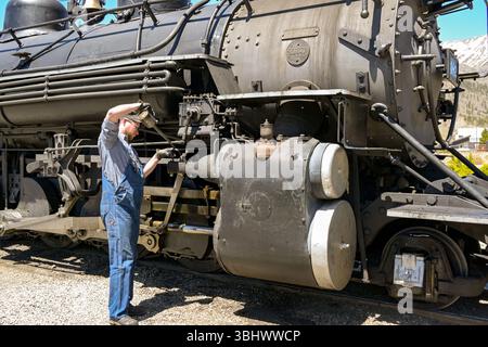 Silverton, Colorado, USA - 23 maggio 2025: Ingegnere ferroviario che lubrifica le ruote di un motore a vapore d'epoca sulla ferrovia a scartamento ridotto Durango e Silverton Foto Stock