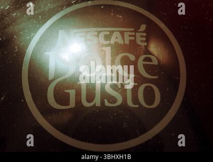 Cacak, Serbia - 10 giugno 2025: Logo Nescafe Dolce gusto su superficie polverosa, vista macro. Foto Stock