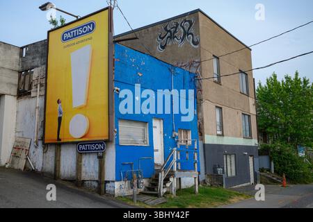 Un vecchio edificio commerciale con un appartamento e un cartellone adiacente a East Vancouver, British Columbia. Foto Stock