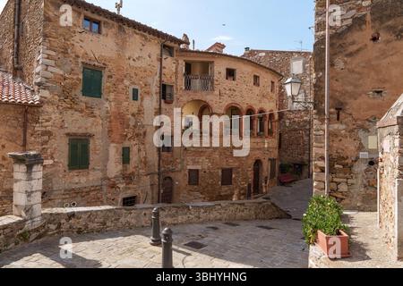 La stretta e antica strada di Campiglia Marittima, un affascinante borgo medievale in Toscana, Italia con edifici in pietra e architettura storica. Foto Stock