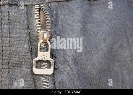 Primo piano di una cerniera aperta sulla borsa da donna. Sfondo nero in tessuto per un design di abbigliamento. Foto Stock