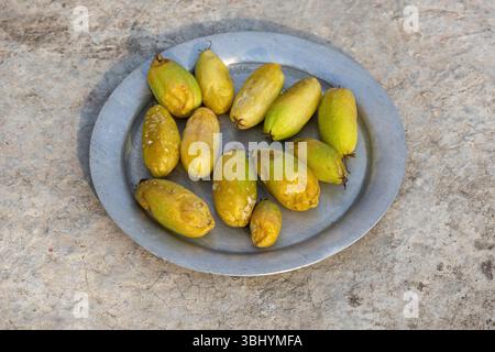Bilimbi overripe (Averrhoa bilimbi), noto anche come cetriolo o albero Sorrel, in argenteria su una superficie in cemento. Foto Stock