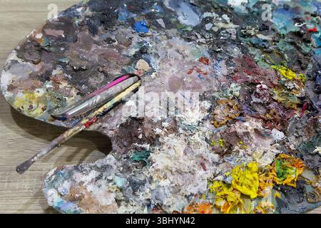 Vivace tavolozza di artisti con vari blocchi colorati e un pennello, perfetta per progetti creativi Foto Stock