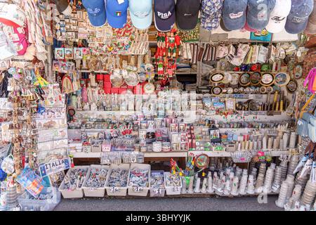Negozio di souvenir colorato a Pisa, Italia, che vende magneti, tazze, cartoline, portachiavi, e miniature delle torri pendenti Foto Stock