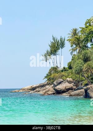 Splendida scena costiera a Phuket, Thailandia, con acque turchesi, coste rocciose e lussureggianti foglie verdi. Un perfetto esempio di brea thailandese Foto Stock