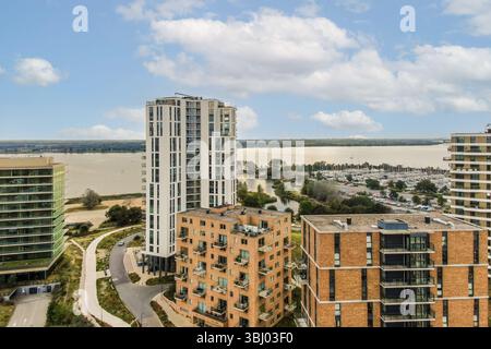 Edifici residenziali contemporanei adagiati su di un tranquillo paesaggio fronte mare, sfoggiano design architettonici innovativi e vegetazione lussureggiante Foto Stock